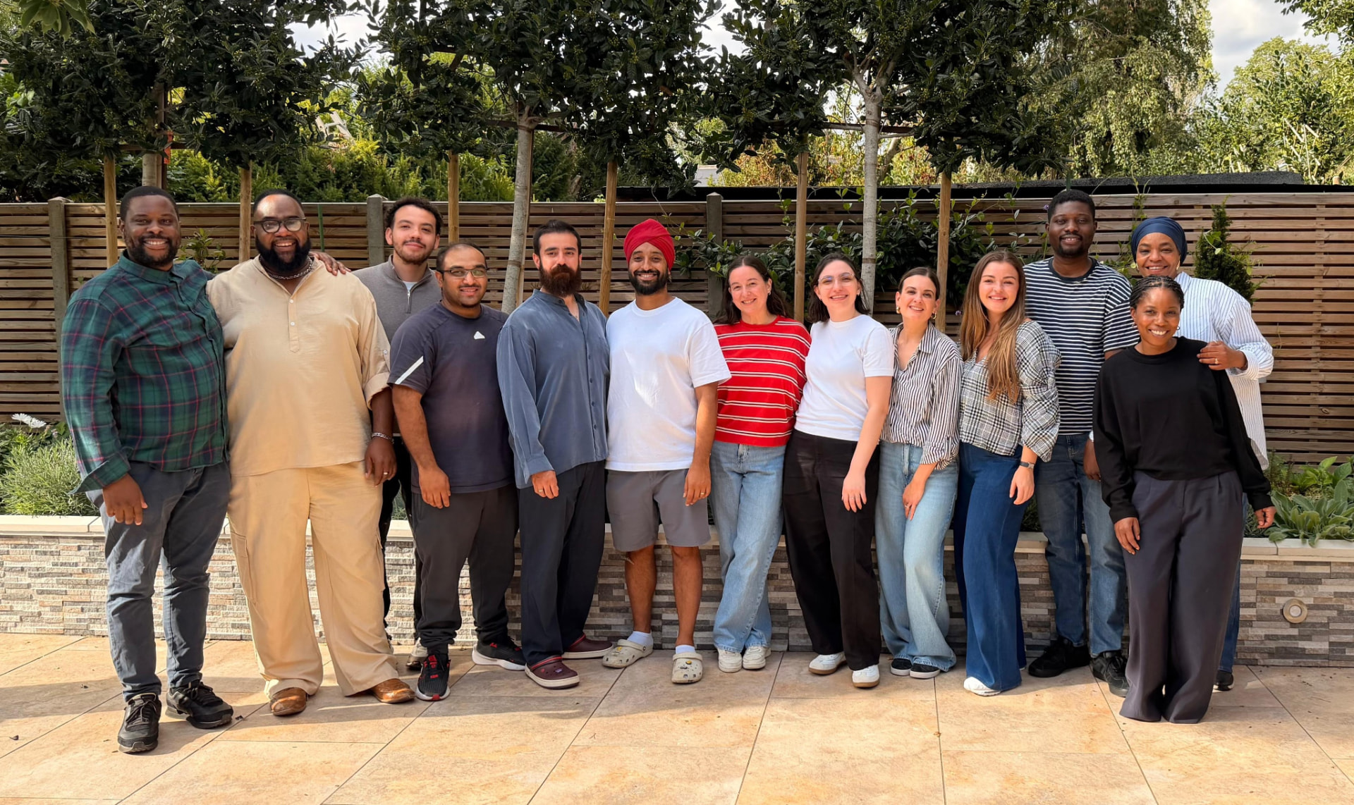 The Diverse Services team standing together in a garden and smiling